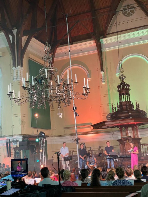 Een band speelt op een podium in een grote, grote kerk